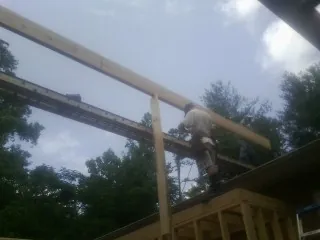 Carpenter setting a ridge beam over a new addition frame — Ice Dam Removal by Roofing Brothers in Cripple Creek