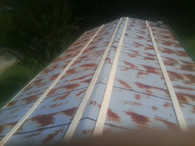 Rusted metal roof panels with new wood purlins before replacement — Storm Damage Roof Repair in Cripple Creek by Roofing Brothers