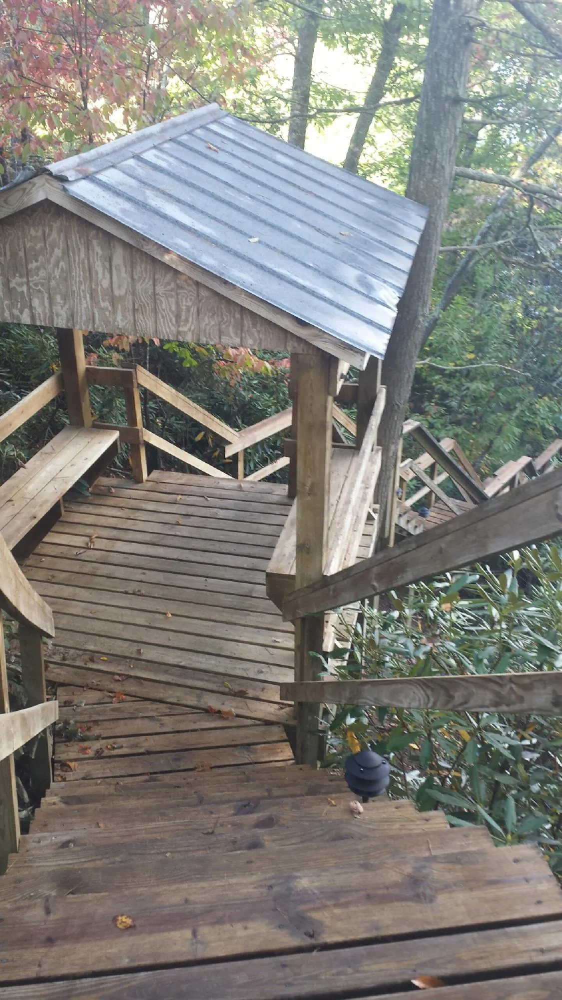 Metal roofed shelter over wooden steps on a wooded walkway — Skylight Repair & Installation work by our crew in Cripple Creek