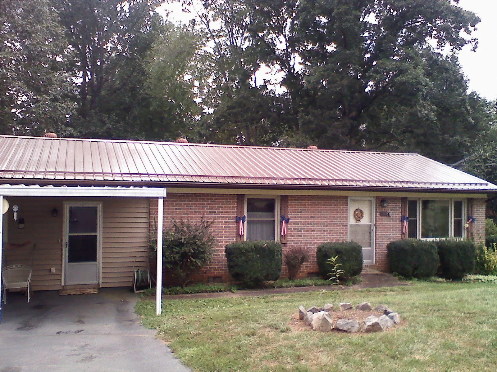 Bronze metal roof and carport on a brick ranch home — Roof Repair work by our crew in Cripple Creek